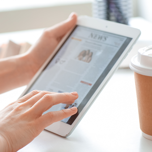 person reading the news on a tablet